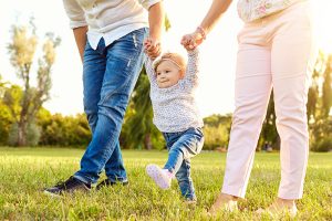 Young adoptee walking with her adoptive parents