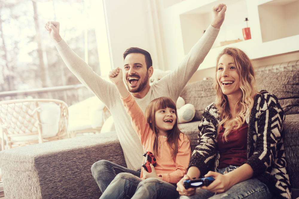 Happy family playing video games at home and having fun together.