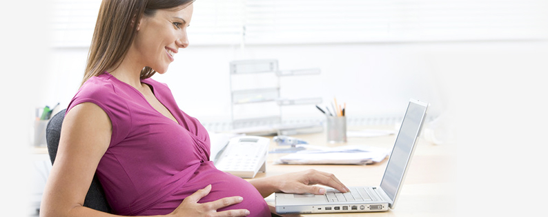 pregnant woman at a desk with a computer