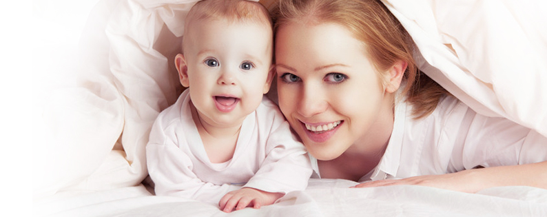 single adoptive mom playing under the covers with her baby