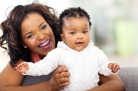 smiling adoptive mom holding her baby girl