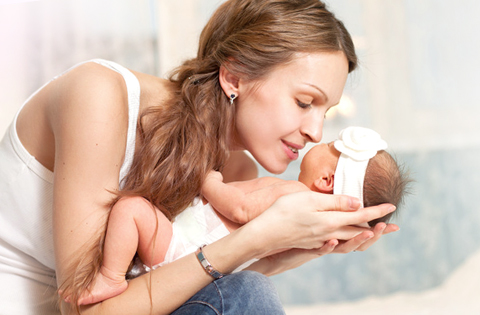 adoptive mom cuddling with newborn baby