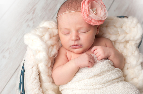 baby girl sleeping in a basket