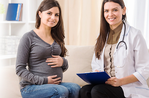 pregnant woman sitting with a doctor