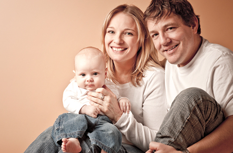 smiling adoptive parents holding their baby