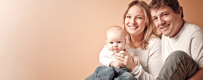 smiling adoptive parents holding their baby
